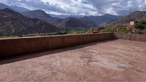 A terrace with a view of mountains and a cloudy sky. - Gite Azoul (Beni Mellal)