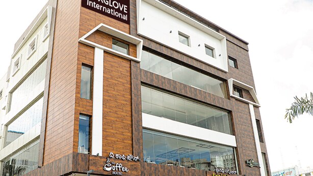 Un hotel de diseño moderno, que destaca un letrero grande para Foxglove International y una cafetería.