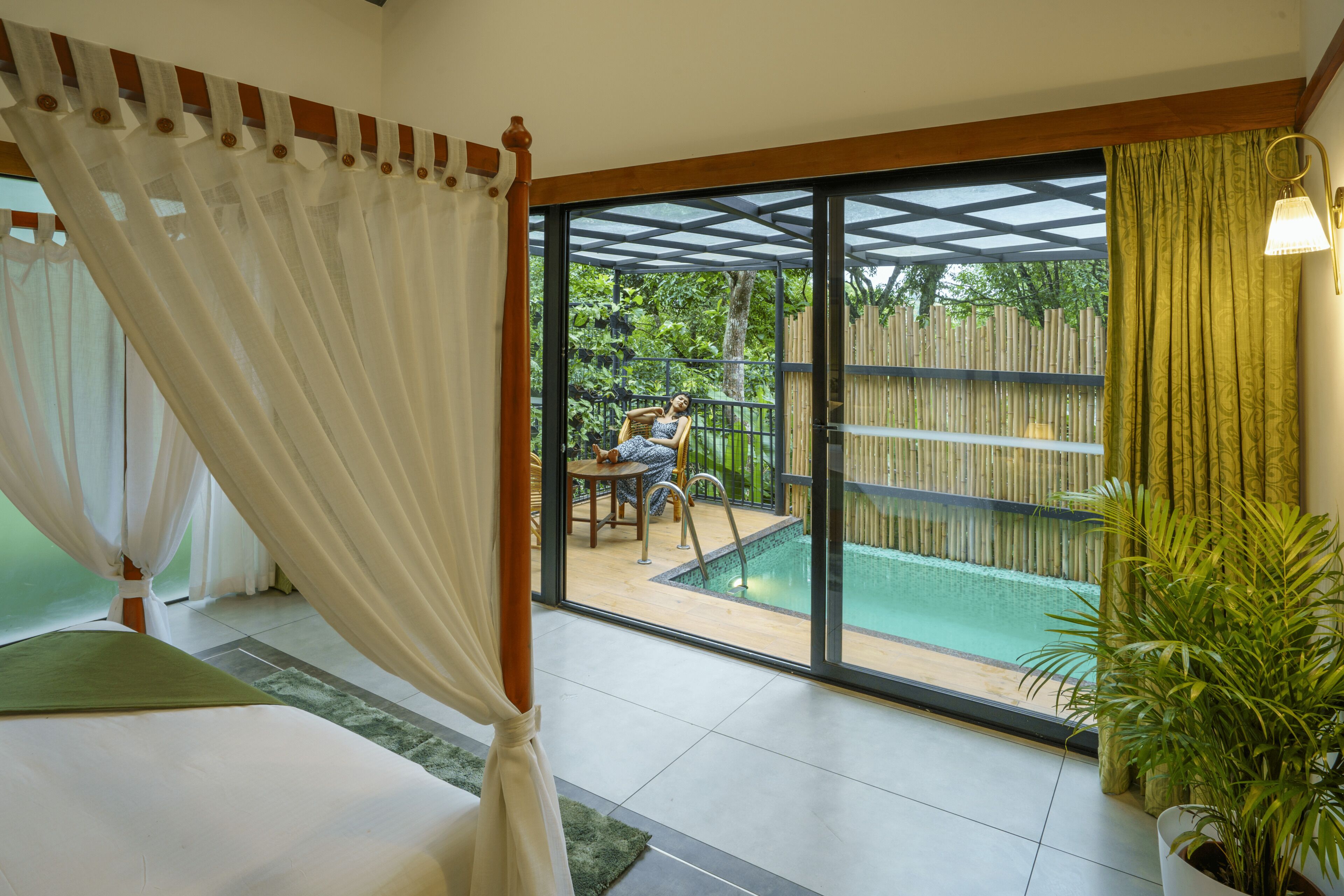 Un dormitorio con una cama grande, una puerta de vidrio que da a un balcón con piscina y vistas al exterior.