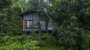 A modern house with a balcony, surrounded by dense greenery. - Crystal Kuruva Nature Resort & Spa (Sulthan Bathery)