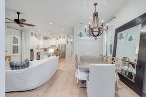 Enjoy meals in this dining area with a large table and comfortable chairs, surrounded by modern kitchen amenities.