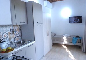 Enjoy cooking in the kitchen with a gas stove and sink, and relax in the adjacent seating area with a bench and TV.