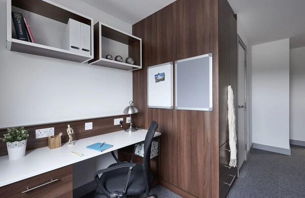 A modern office space with a desk, chair, shelves, and a whiteboard. - The Foundry (Leeds)