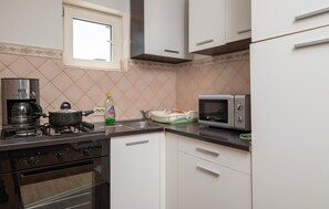 Een koelkast, een oven, een kookplaat, een koffiezetapparaat/waterkoker