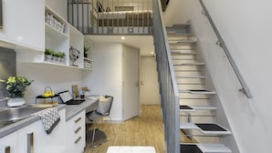 A modern kitchen with white cabinets, a built-in stove, and a countertop with a laptop and a plant. - For Students Only Stepney Yard in Newcastle (Newcastle-upon-Tyne)