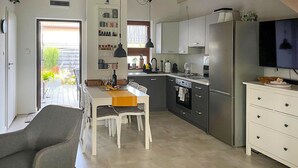 Eine moderne Küche mit Essbereich, einem Kühlschrank und einem Fernseher.