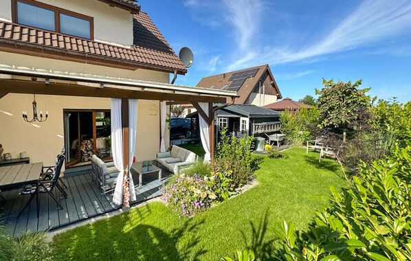 A house with a covered patio, a lawn, and a garden. - 2 bedroom amazing home in Pogorzelica (Pogorzelica)