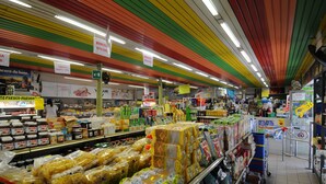 A supermarket aisle with various food products and a colorful ceiling. - Happy Camp in Camping Riccione (Riccione)