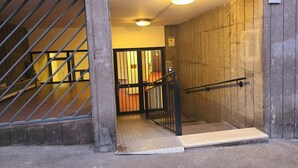 Een inkom met een metalen poort, een trap en een bord met het nummer 10.