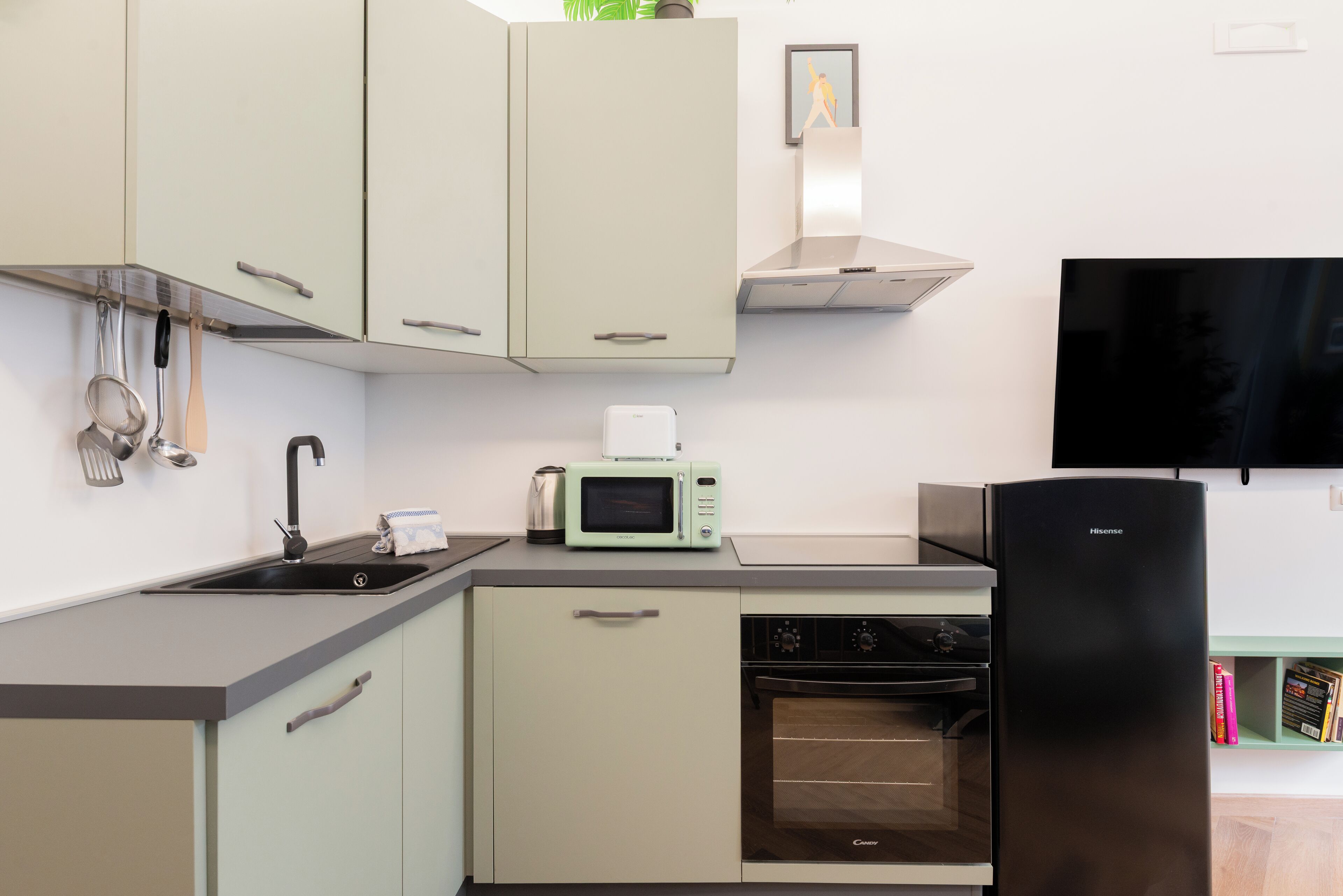 A compact kitchen with a sink, microwave, oven, and refrigerator.