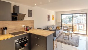 A modern kitchen with a wooden countertop, built-in oven, and a dining area with a round table and chairs.