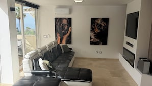 A modern living room with a sectional sofa, a flat-screen TV, and artwork on the walls.