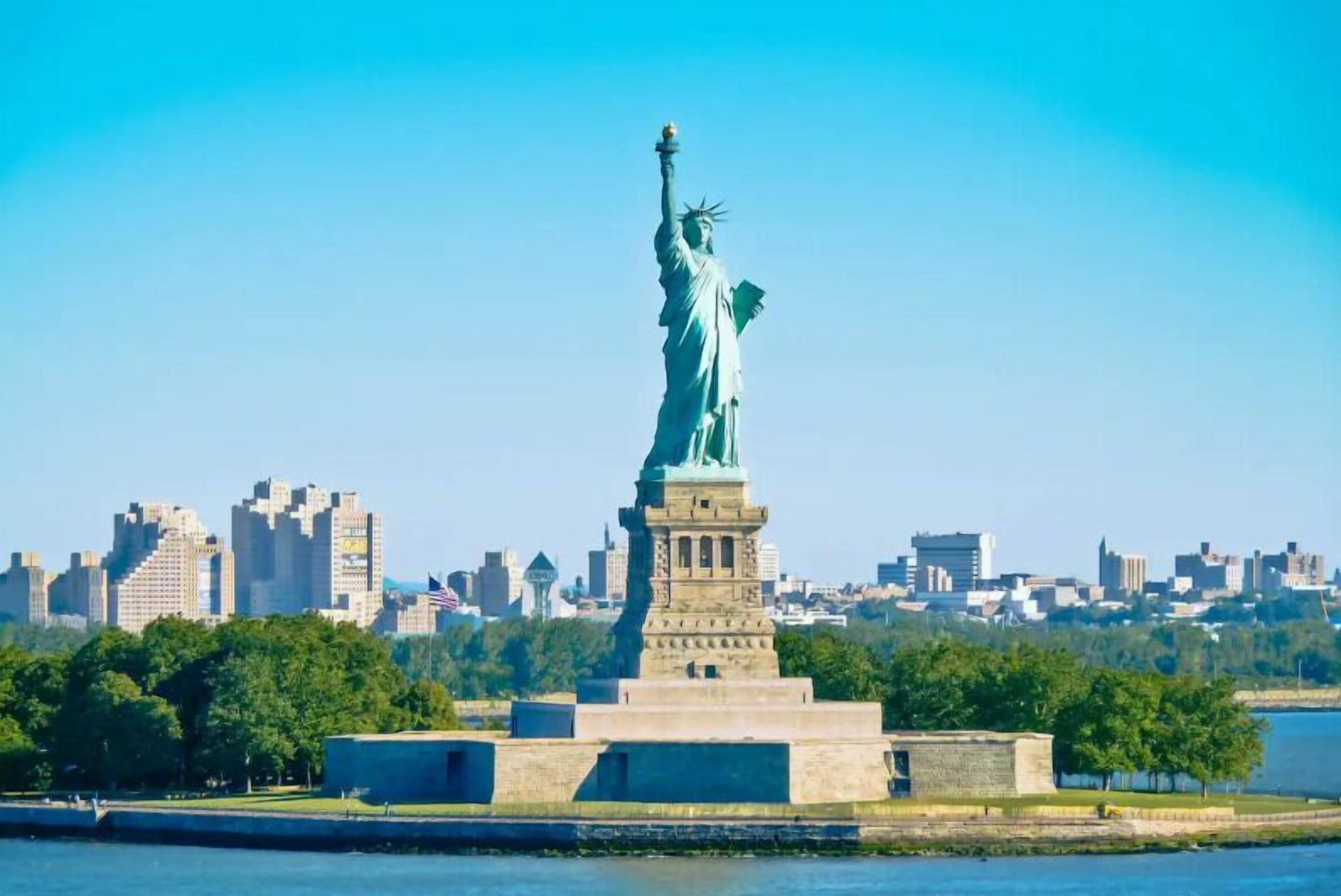 The Statue of Liberty in a cityscape with buildings in the background.