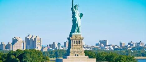 The Statue of Liberty in a cityscape with buildings in the background.