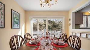 A dining room with a wooden table set for six, surrounded by chairs. - Walk to Water, near Downtown Chatham! (Chatham)