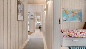 A hallway leading to a bedroom with a bed, a world map on the wall, and a framed picture on the left. - Beautiful home in Fårevejle with WiFi (Fårevejle)