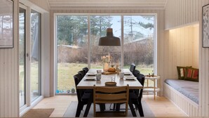 A dining area with a table set for four, a pendant light, and a view of the outdoors through large windows. - Beautiful home in Fårevejle with WiFi (Fårevejle)