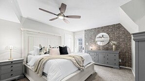 A bedroom with a bed, nightstands, a dresser, a ceiling fan, and a textured wall. - Dome Manor / Pool + Hot Tub + Two Game Rooms (Bedford)