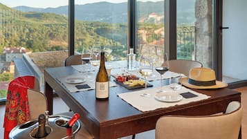 A dining table set for two with wine glasses, a bottle of wine, and a plate of appetizers.