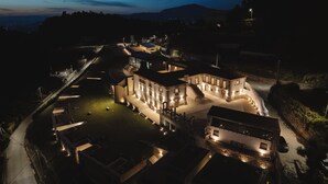 Un grand bâtiment illuminé, doté de plusieurs ailes et d’une cour centrale.