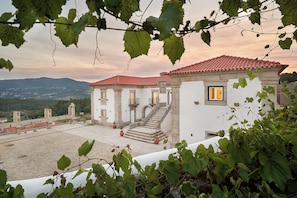 A building with a red-tiled roof, a staircase, and a view of the surrounding landscape. - The Vinea Collection Hotel by Piamonte Hotels (Monção)