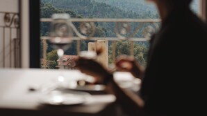A person sitting at a table with a view of a mountainous landscape through a window. - The Vinea Collection Hotel by Piamonte Hotels (Monção)