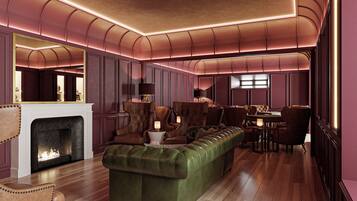 A spacious living room with a fireplace, leather furniture, and a modern ceiling design.