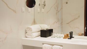 Une salle de bain moderne avec un meuble-lavabo en marbre, un lavabo, un bidet et un miroir.