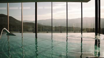 Alberca techada, sombrillas en la alberca y camastros