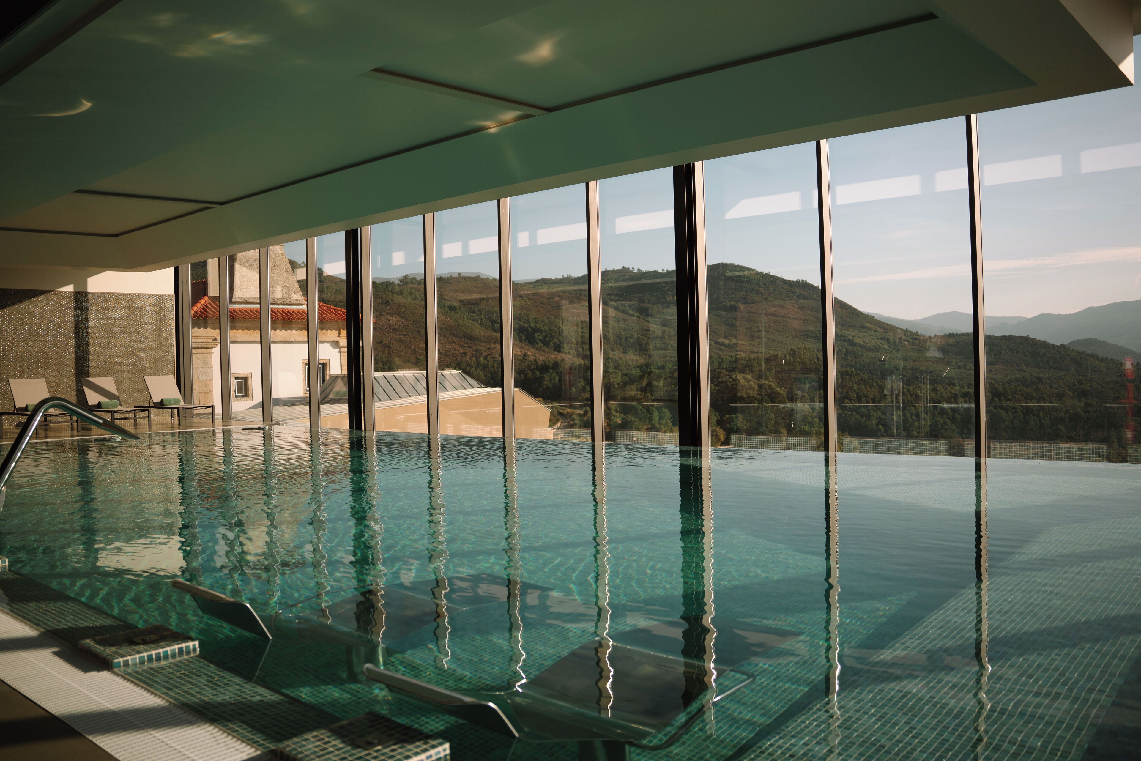 室内游泳池，池畔遮阳伞，日光浴躺椅