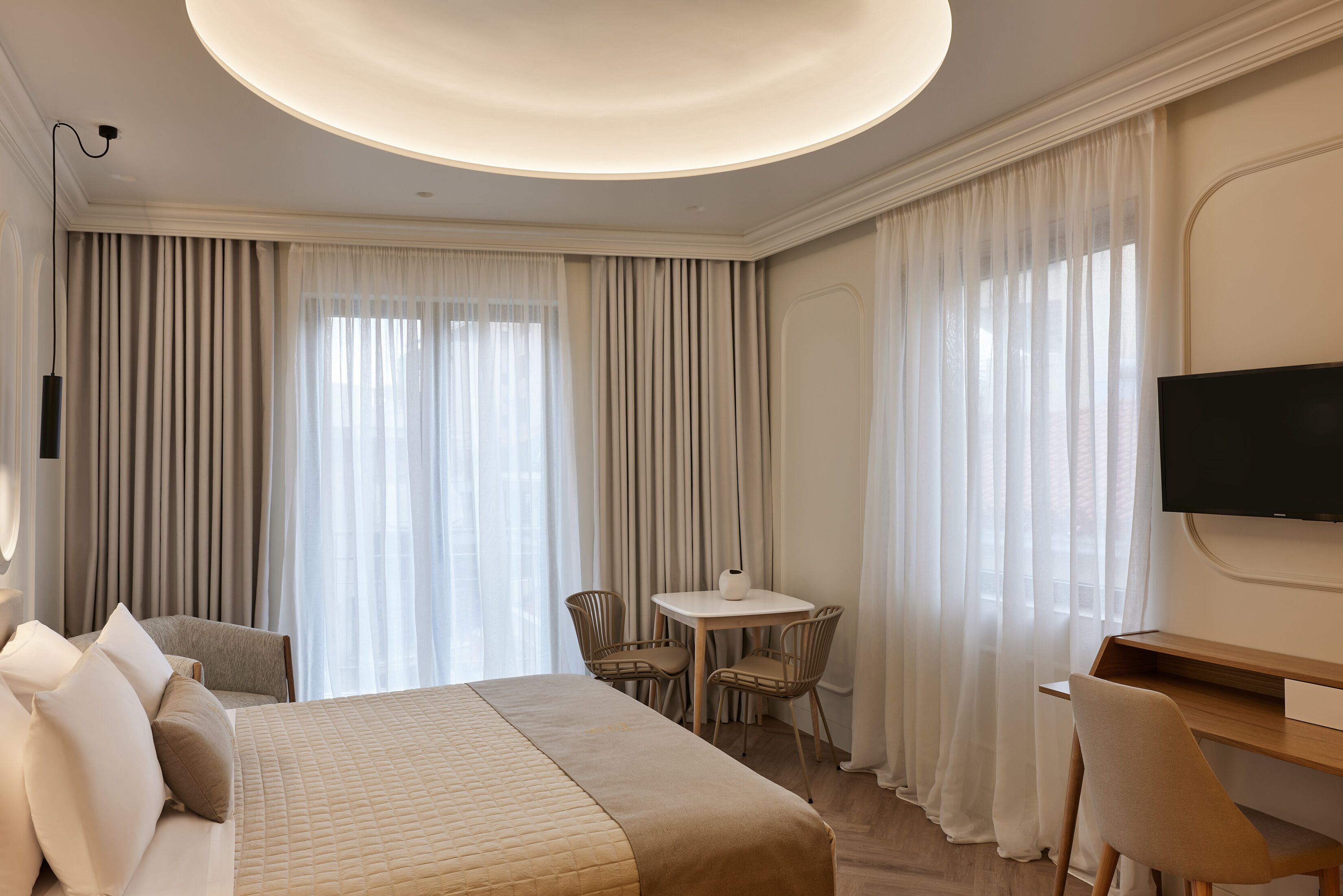Una habitación de hotel con una cama grande, un escritorio, una silla y un televisor.