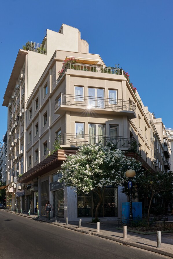 A multi-story hotel with balconies, a flower box, and a storefront.