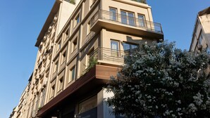 Un immeuble à plusieurs étages, doté de balcons, de grandes fenêtres et surplombant un ciel dégagé.