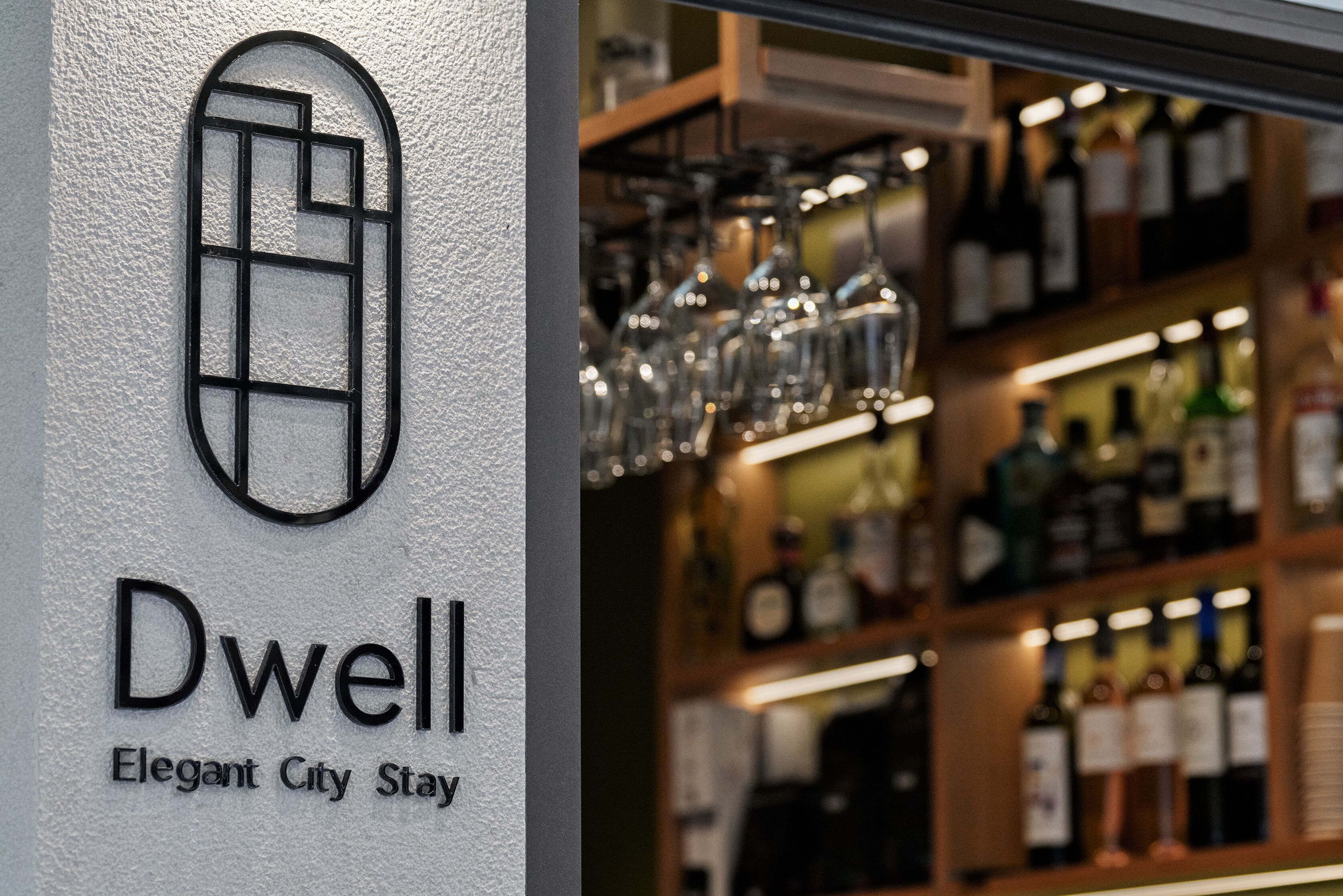 A sign with the name 'Dwell' and the tagline 'Elegant City Stay'.