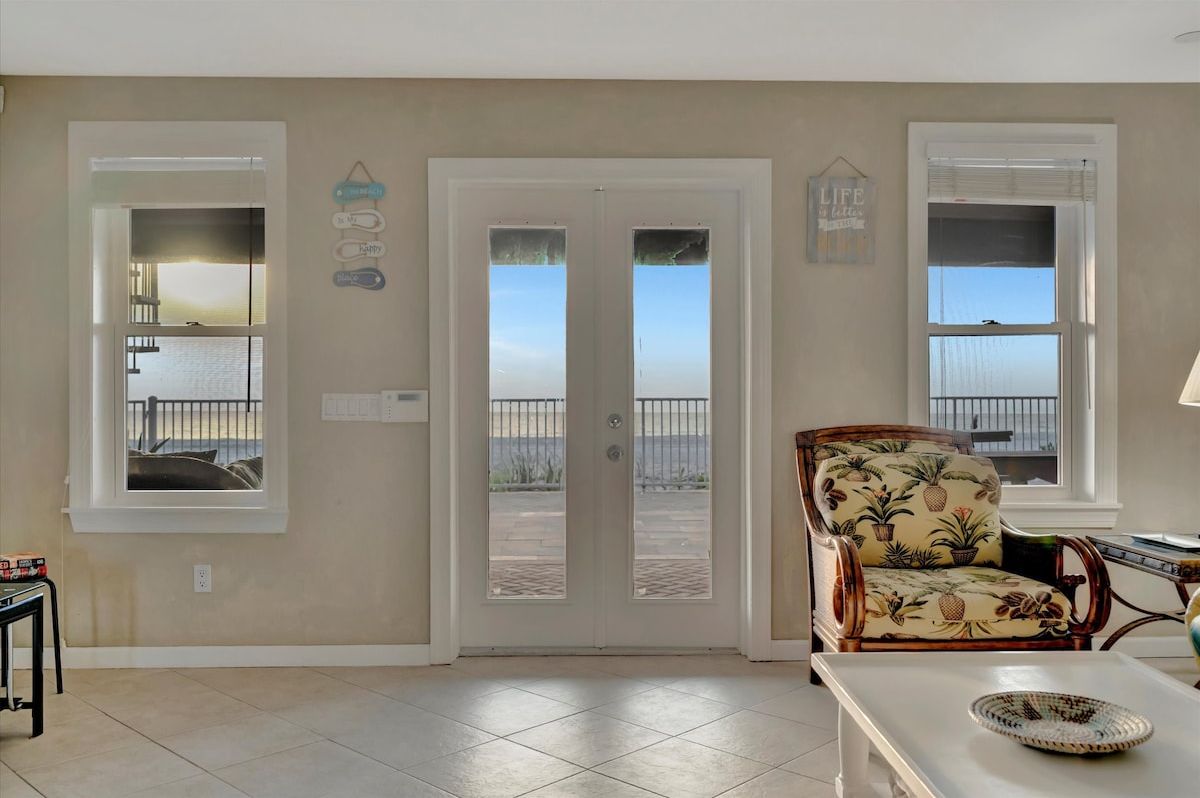 Step through these doors onto your private deck, where the ocean stretches endlessly before you and soft coastal breezes invite you to unwind in your tropical-themed retreat.