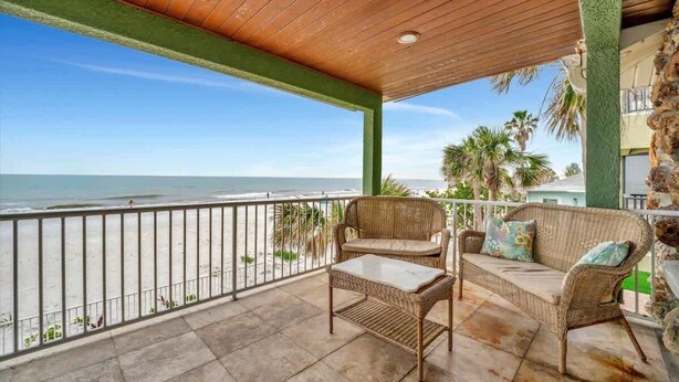 A balcony with wicker furniture overlooking a beach. - Relax on the Beach! Private Balcony Oceanview (Indian Rocks Beach)