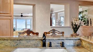 Step into your gourmet kitchen where granite countertops meet elegant design. Through the windows beyond, you'll catch glimpses of the ocean—your daily reminder that paradise is just outside.