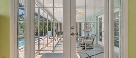 French doors open to your private patio, where sunlit seating invites you to relax beside the sparkling pool and soak up the warm Florida sunshine.