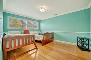 Sleep soundly in this cheerful bedroom with warm wood floors and twin beds perfect for restful nights during your stay. - BBQ & Pool Day! Large 4B 12 minutes to the Beach! (Largo)