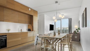 Une cuisine moderne avec des meubles en bois, un coin repas comprenant une table et des chaises, et une grande fenêtre offrant une belle vue.