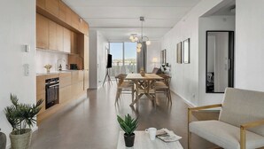 Une cuisine moderne avec des meubles en bois, un coin repas avec une table et des chaises, et un espace de vie avec un canapé et une table basse.