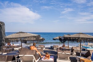 Playa privada, arena negra, bar en la playa