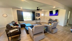 Una sala de estar moderna con sofá, mesa de centro y televisor.