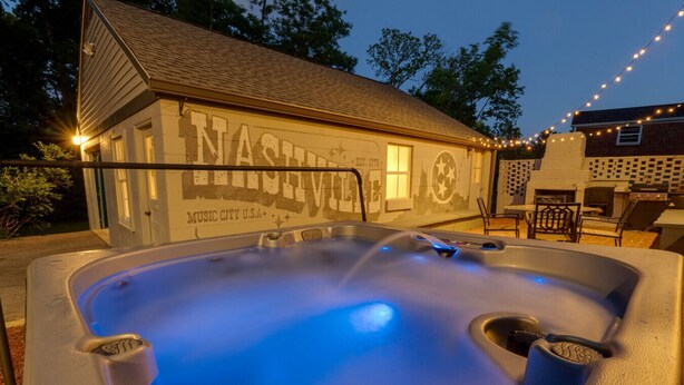 A hot tub with a blue light, a building with 'Nashville Music City USA' written on it, and outdoor seating.