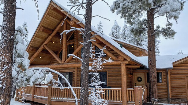 A wooden cabin with a sloped roof, a porch, and a snow-covered landscape. - Fire Pit: Cozy Winter Cabin, 45 Mi to Sunrise Park (Show Low)
