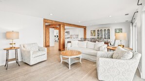 A spacious living room with a sofa, armchairs, a coffee table, and a dining area with a table and chairs. - 632 Newhaven (Fripp Island)