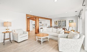 A spacious living room with a sofa, armchairs, a coffee table, and a dining area with a table and chairs. - 632 Newhaven (Fripp Island)