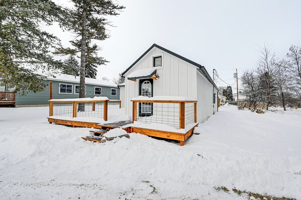 A snow-covered building with a wooden deck and a small porch area. - 1 Mi to Main Street Polson: Updated Home w/ Deck! (Polson)