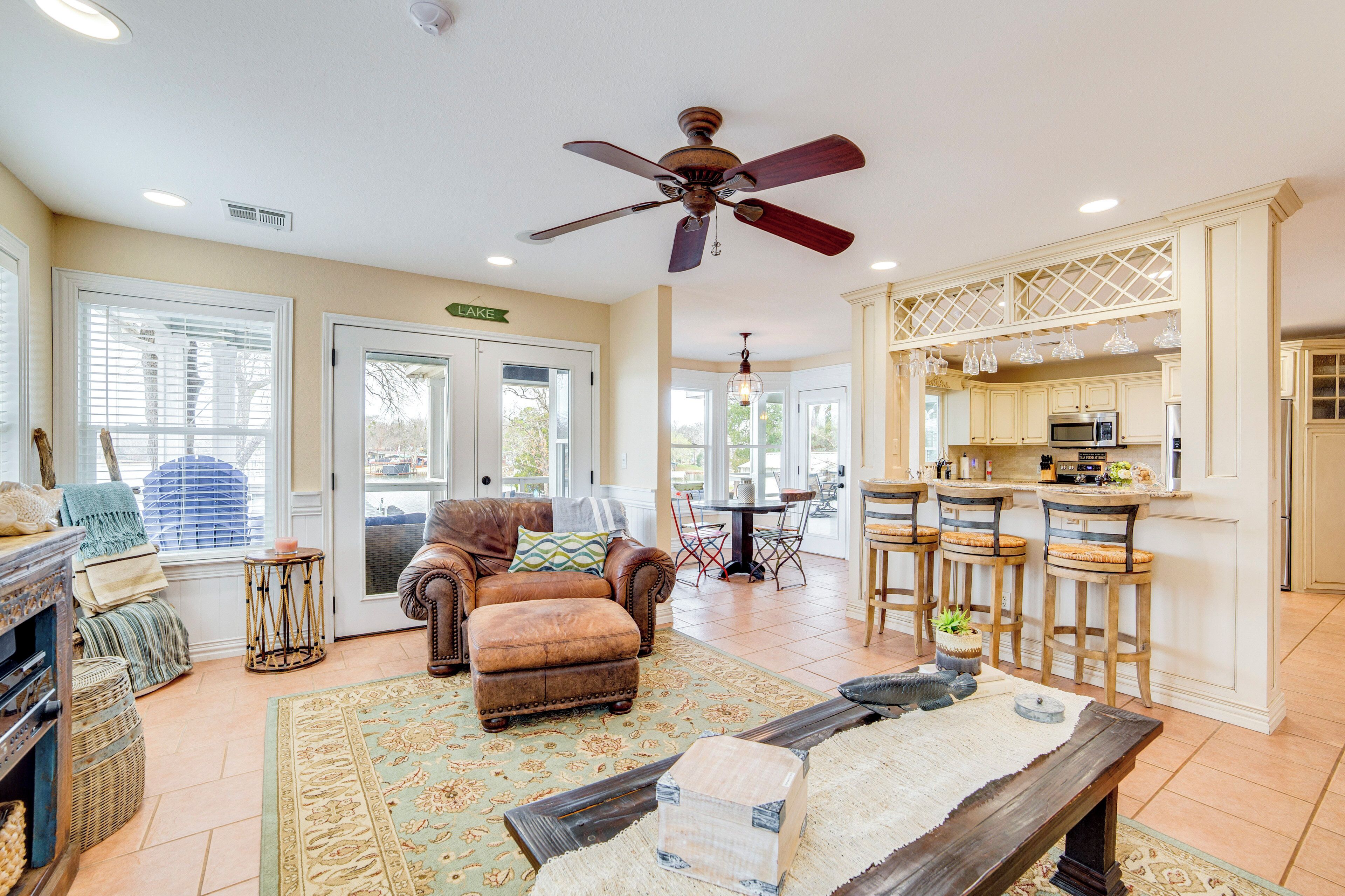 A spacious living room with a fireplace, a dining area, and a kitchen with bar stools.
