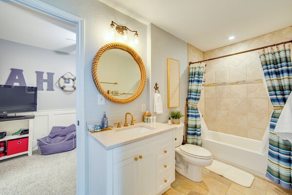 A bathroom with a sink, toilet, and shower. There is a mirror above the sink and a towel rack on the wall. - Dock & Lake Access: Gem on Cedar Creek Reservoir (Mabank)